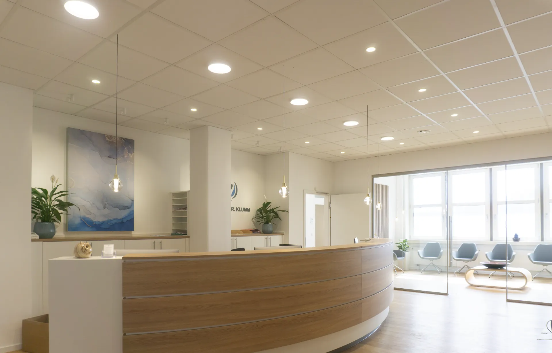 Eingangsbereich einer Praxis, beleuchtet mit Kugelpendelleuchte Alaska, Downlight Stram und Downlight Buddy.