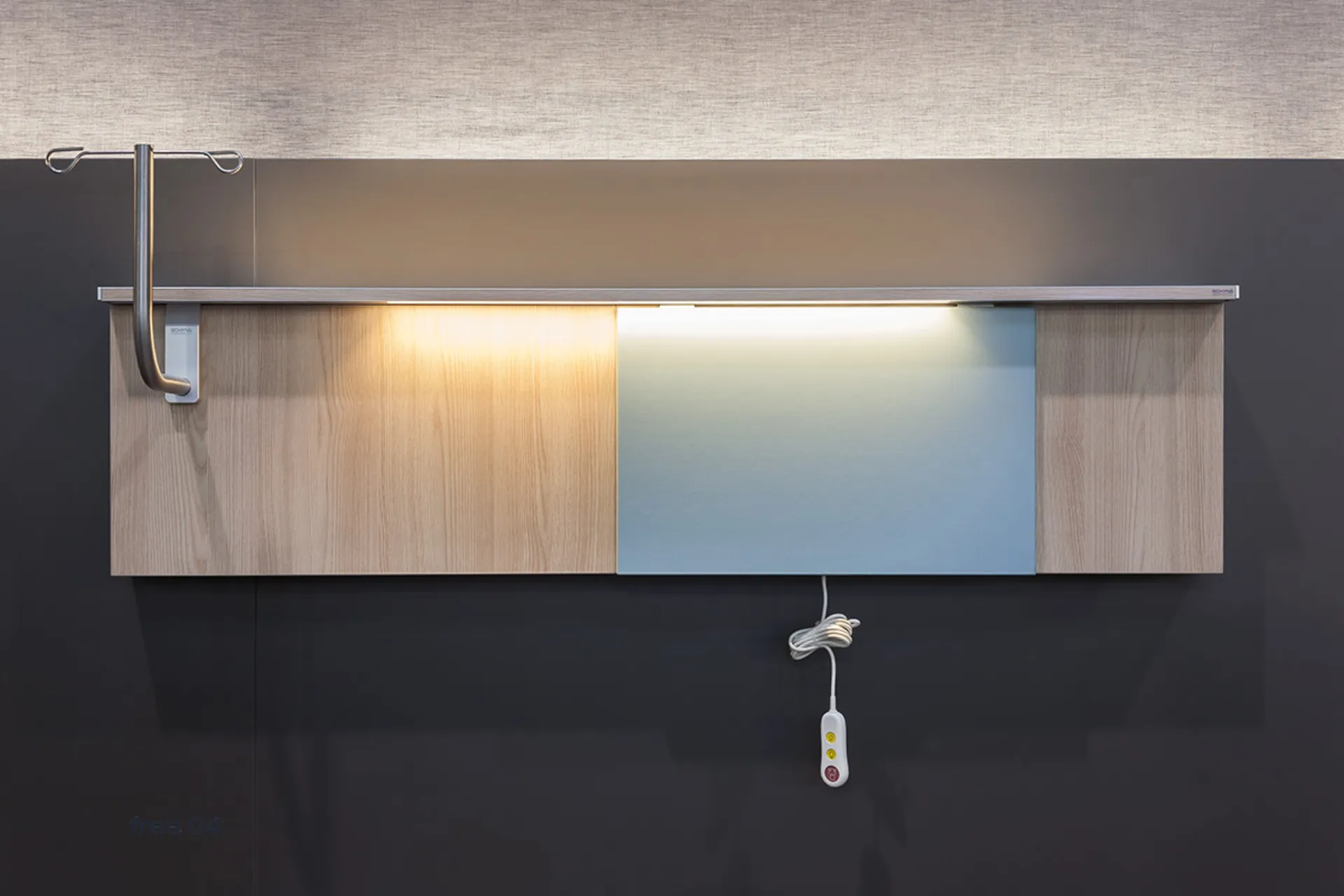 Wandmontierte medizinische Einrichtung mit Holzverkleidung, integriertem Licht und einem hängenden Bedienelement mit Kabel